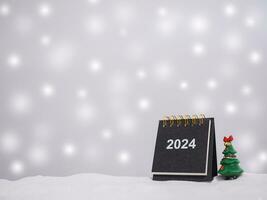 Close up calendar and christmas trees with shiny light for New Year and Christmas 2024 concept. photo