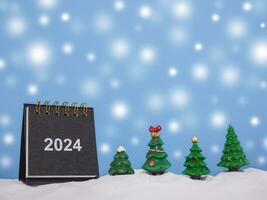 Close up calendar and christmas trees with shiny light for New Year and Christmas 2024 concept. photo