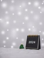 Close up calendar and christmas trees with shiny light for New Year and Christmas 2024 concept. photo