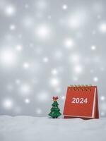 Close up calendar and christmas trees with shiny light for New Year and Christmas 2024 concept. photo