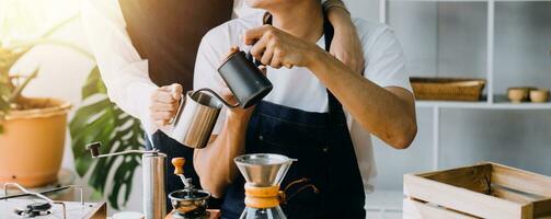 Happy young adult couple making breakfast and drinking coffee together in cozy home kitchen in morning at home. Preparing meal and smiling. Lifestyle, leisure and Love concept. photo