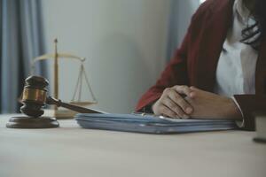 Business and lawyers discussing contract papers with brass scale on desk in office. Law, legal services, advice, justice and law concept picture with film grain effect photo