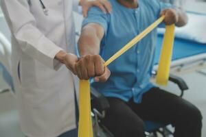 Doctor or Physiotherapist working examining treating injured arm of athlete male patient, stretching and exercise, Doing the Rehabilitation therapy pain in clinic. photo