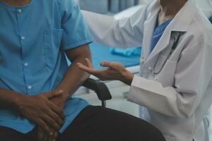 Doctor or Physiotherapist working examining treating injured arm of athlete male patient, stretching and exercise, Doing the Rehabilitation therapy pain in clinic. photo