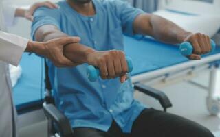 Doctor or Physiotherapist working examining treating injured arm of athlete male patient, stretching and exercise, Doing the Rehabilitation therapy pain in clinic. photo