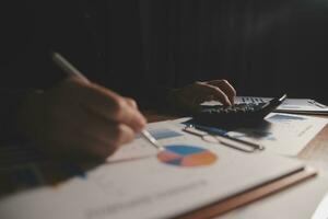 Close up businessman hand using calculator and working with laptop calculate about finance accounting at coffeeshop outdor.finance accounting concept photo