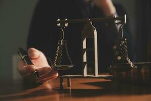 Business and lawyers discussing contract papers with brass scale on desk in office. Law, legal services, advice, justice and law concept picture with film grain effect photo