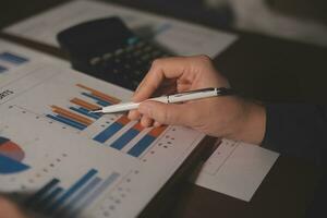Close up businessman hand using calculator and working with laptop calculate about finance accounting at coffeeshop outdor.finance accounting concept photo