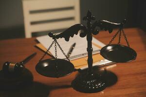 Business and lawyers discussing contract papers with brass scale on desk in office. Law, legal services, advice, justice and law concept picture with film grain effect photo