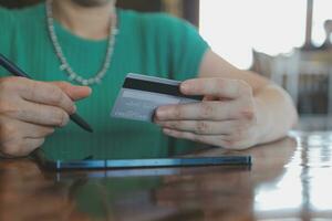 Woman is holding credit card and using laptop computer. Online shopping concept. Close up. photo