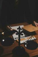Business and lawyers discussing contract papers with brass scale on desk in office. Law, legal services, advice, justice and law concept picture with film grain effect photo