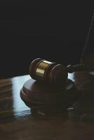 Justice and law concept.Male judge in a courtroom with the gavel, working with, computer and docking keyboard, eyeglasses, on table in morning light photo
