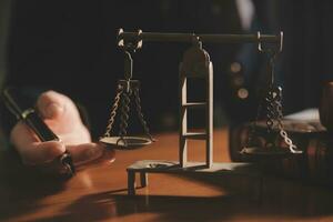 Business and lawyers discussing contract papers with brass scale on desk in office. Law, legal services, advice, justice and law concept picture with film grain effect photo