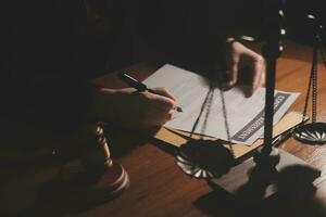 Business and lawyers discussing contract papers with brass scale on desk in office. Law, legal services, advice, justice and law concept picture with film grain effect photo