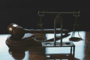 Justice and law concept.Male judge in a courtroom with the gavel, working with, computer and docking keyboard, eyeglasses, on table in morning light photo