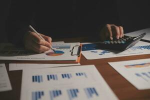 Close up businessman hand using calculator and working with laptop calculate about finance accounting at coffeeshop outdor.finance accounting concept photo