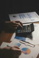 Close up businessman hand using calculator and working with laptop calculate about finance accounting at coffeeshop outdor.finance accounting concept photo