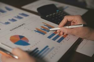 Close up businessman hand using calculator and working with laptop calculate about finance accounting at coffeeshop outdor.finance accounting concept photo