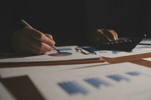 Close up businessman hand using calculator and working with laptop calculate about finance accounting at coffeeshop outdor.finance accounting concept photo