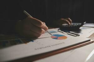 Close up businessman hand using calculator and working with laptop calculate about finance accounting at coffeeshop outdor.finance accounting concept photo