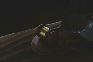 Justice and law concept.Male judge in a courtroom with the gavel, working with, computer and docking keyboard, eyeglasses, on table in morning light photo