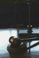 Justice and law concept.Male judge in a courtroom with the gavel, working with, computer and docking keyboard, eyeglasses, on table in morning light photo
