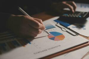 Close up businessman hand using calculator and working with laptop calculate about finance accounting at coffeeshop outdor.finance accounting concept photo