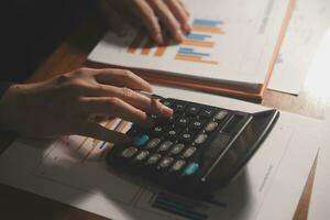 Close up businessman hand using calculator and working with laptop calculate about finance accounting at coffeeshop outdor.finance accounting concept photo