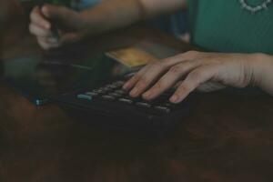 Close up businessman hand using calculator and working with laptop calculate about finance accounting at coffeeshop outdor.finance accounting concept photo
