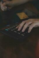 Close up businessman hand using calculator and working with laptop calculate about finance accounting at coffeeshop outdor.finance accounting concept photo