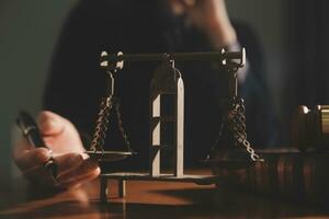 Business and lawyers discussing contract papers with brass scale on desk in office. Law, legal services, advice, justice and law concept picture with film grain effect photo