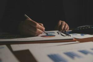 Close up businessman hand using calculator and working with laptop calculate about finance accounting at coffeeshop outdor.finance accounting concept photo