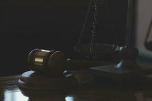 Justice and law concept.Male judge in a courtroom with the gavel, working with, computer and docking keyboard, eyeglasses, on table in morning light photo