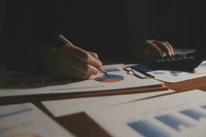 Close up businessman hand using calculator and working with laptop calculate about finance accounting at coffeeshop outdor.finance accounting concept photo