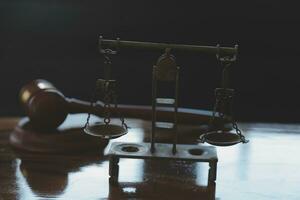 Justice and law concept.Male judge in a courtroom with the gavel, working with, computer and docking keyboard, eyeglasses, on table in morning light photo