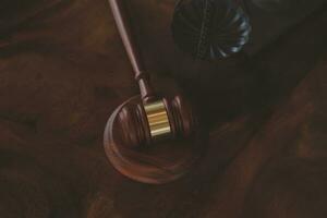 Justice and law concept.Male judge in a courtroom with the gavel, working with, computer and docking keyboard, eyeglasses, on table in morning light photo