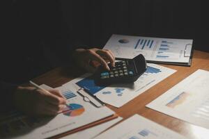 Close up businessman hand using calculator and working with laptop calculate about finance accounting at coffeeshop outdor.finance accounting concept photo