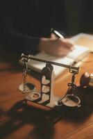 Business and lawyers discussing contract papers with brass scale on desk in office. Law, legal services, advice, justice and law concept picture with film grain effect photo