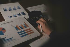Close up businessman hand using calculator and working with laptop calculate about finance accounting at coffeeshop outdor.finance accounting concept photo