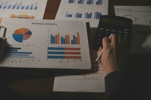Close up businessman hand using calculator and working with laptop calculate about finance accounting at coffeeshop outdor.finance accounting concept photo