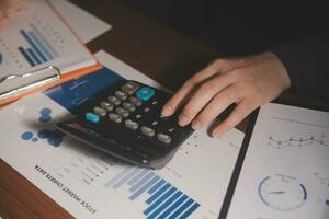 Close up businessman hand using calculator and working with laptop calculate about finance accounting at coffeeshop outdor.finance accounting concept photo