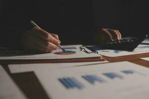 Close up businessman hand using calculator and working with laptop calculate about finance accounting at coffeeshop outdor.finance accounting concept photo