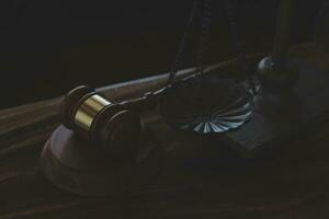 Justice and law concept.Male judge in a courtroom with the gavel, working with, computer and docking keyboard, eyeglasses, on table in morning light photo