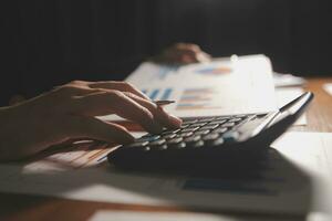 Close up businessman hand using calculator and working with laptop calculate about finance accounting at coffeeshop outdor.finance accounting concept photo