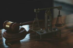 Justice and law concept.Male judge in a courtroom with the gavel, working with, computer and docking keyboard, eyeglasses, on table in morning light photo