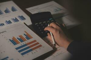Close up businessman hand using calculator and working with laptop calculate about finance accounting at coffeeshop outdor.finance accounting concept photo