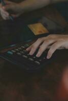 Close up businessman hand using calculator and working with laptop calculate about finance accounting at coffeeshop outdor.finance accounting concept photo