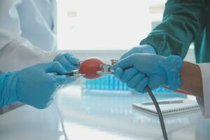 Mature doctors and young nurses stacking hands together at hospital. Close up hands of medical team stacking hands. Group of successful medical doctors and nurses stack of hands. photo