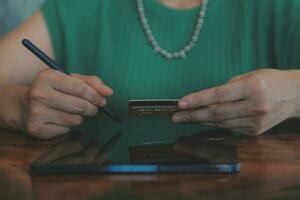 Woman is holding credit card and using laptop computer. Online shopping concept. Close up. photo