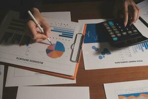 Close up businessman hand using calculator and working with laptop calculate about finance accounting at coffeeshop outdor.finance accounting concept photo